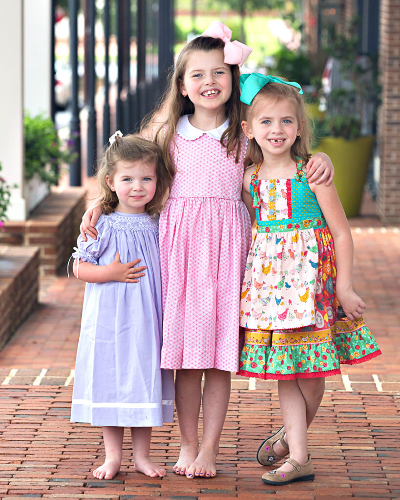 Family of three little girls posing in bright color dresses for professional pictures in Columbus, GA, by Jill Welch Photogarphyh